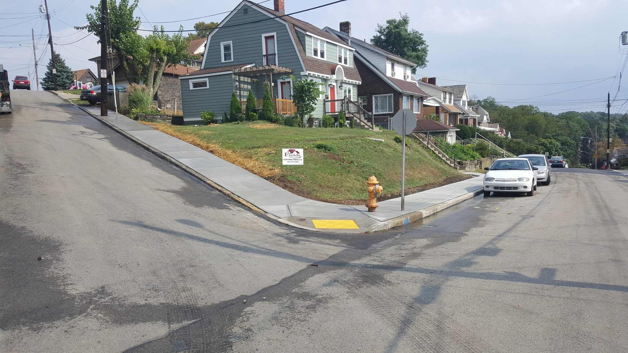 A street corner with a fire hydrant and a yellow sign.