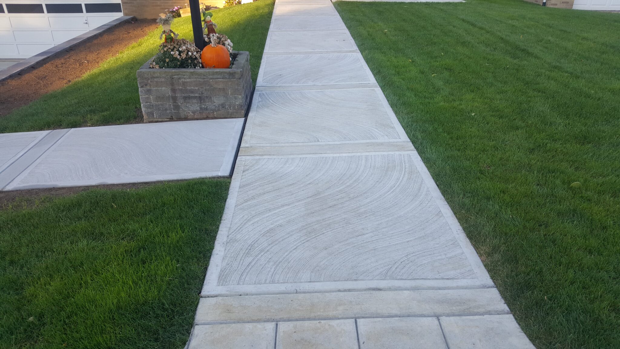 A walkway with grass and concrete in the middle of it.