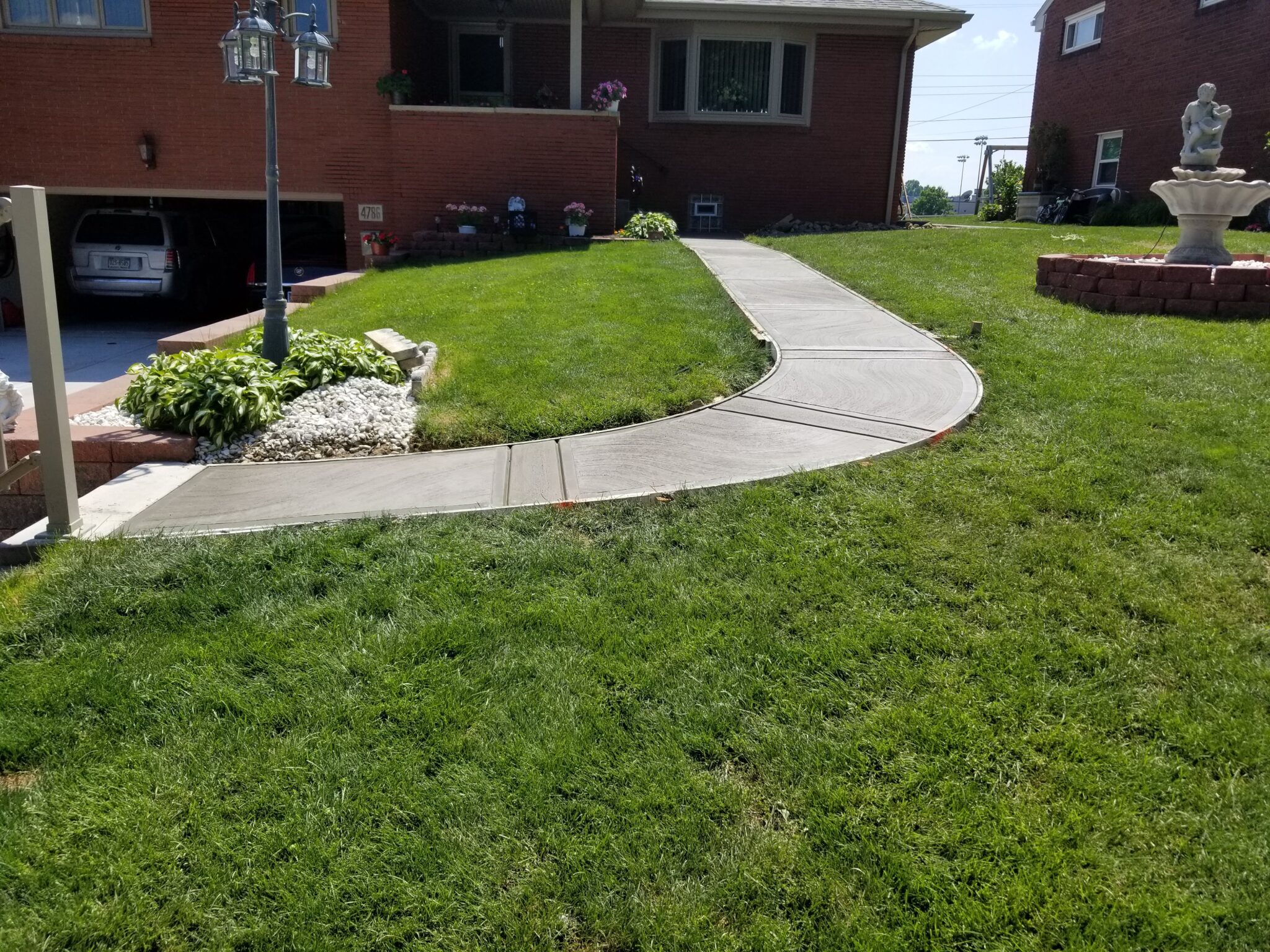 A lawn with grass and concrete in the middle of it.