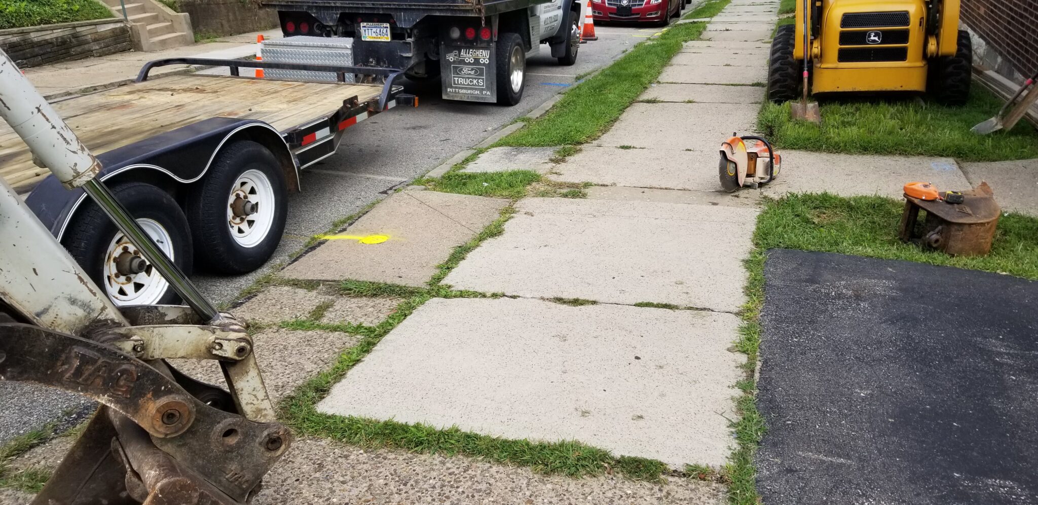 A dog laying on the sidewalk next to a truck.