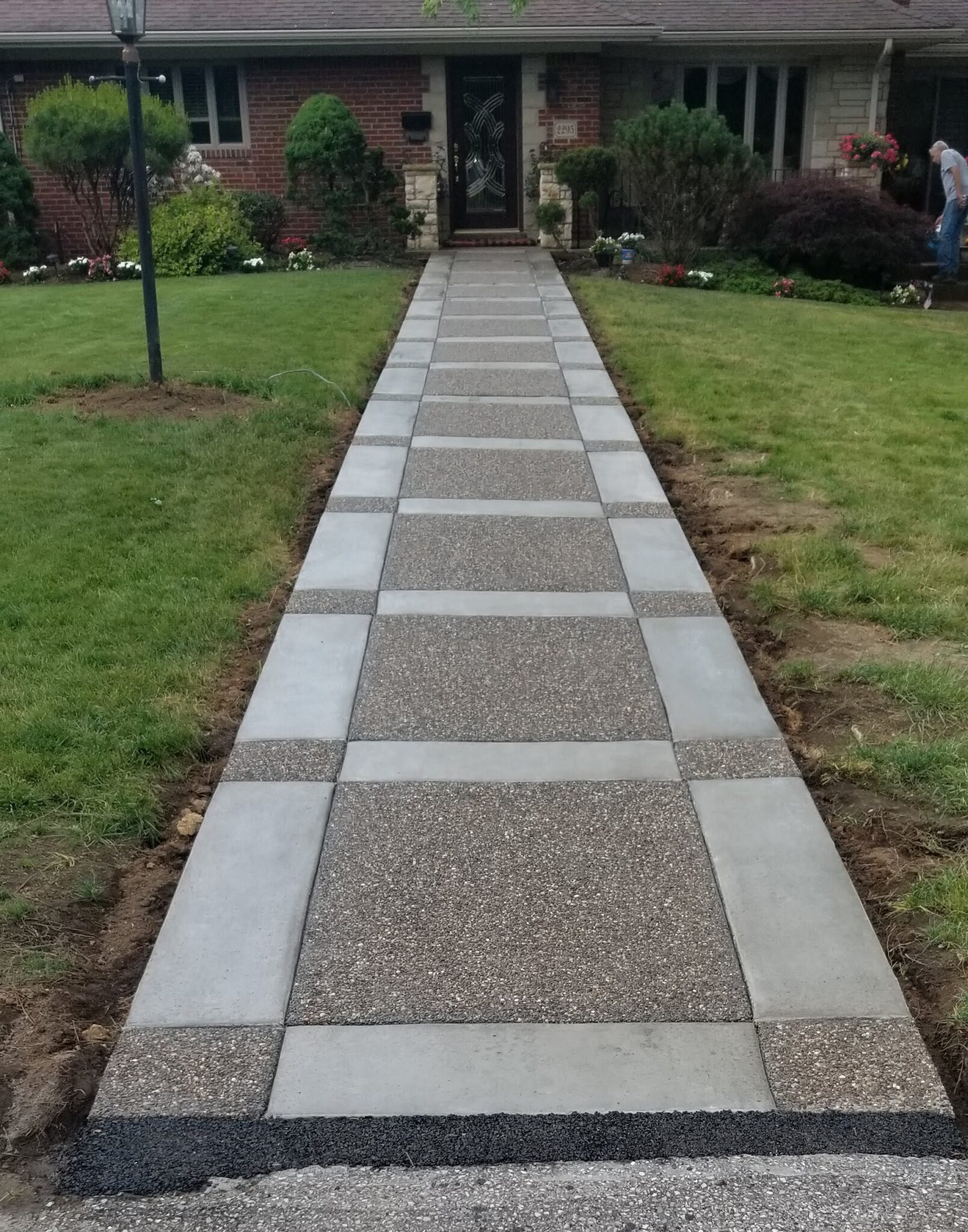 A walkway with stone and concrete in the middle of a yard.