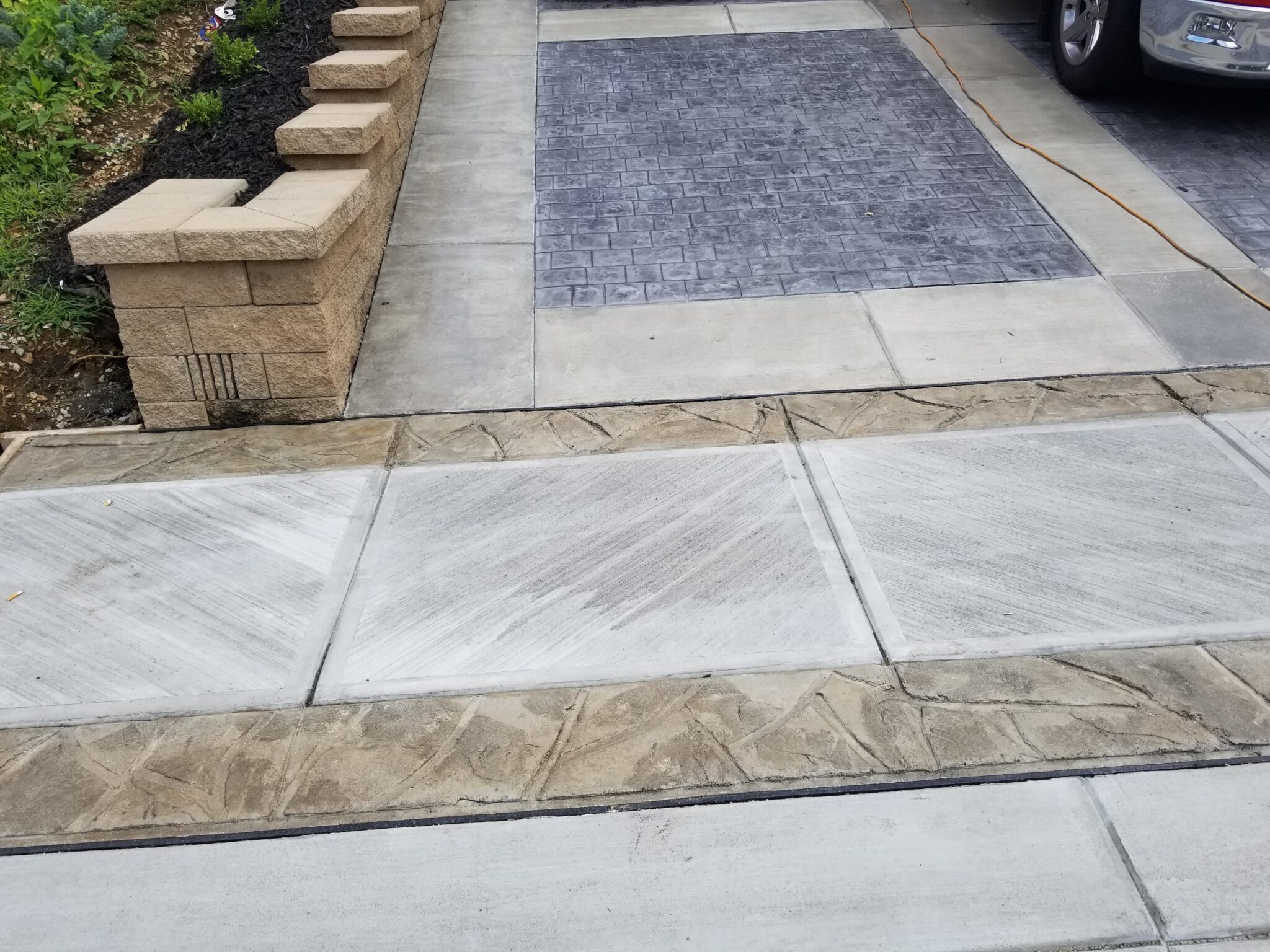 A sidewalk with concrete and stone on it.