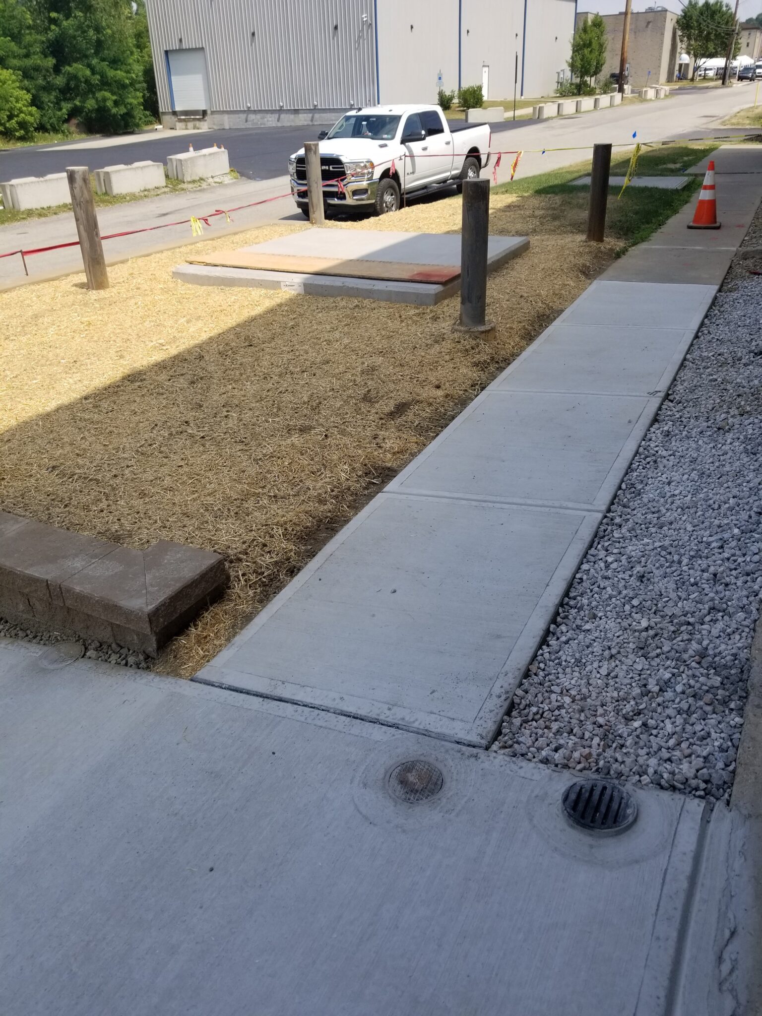 A sidewalk with gravel and concrete on the side.