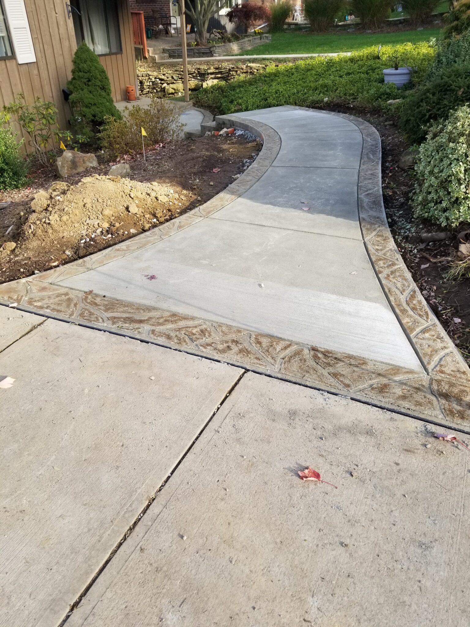A walkway with a concrete slab and stone border.