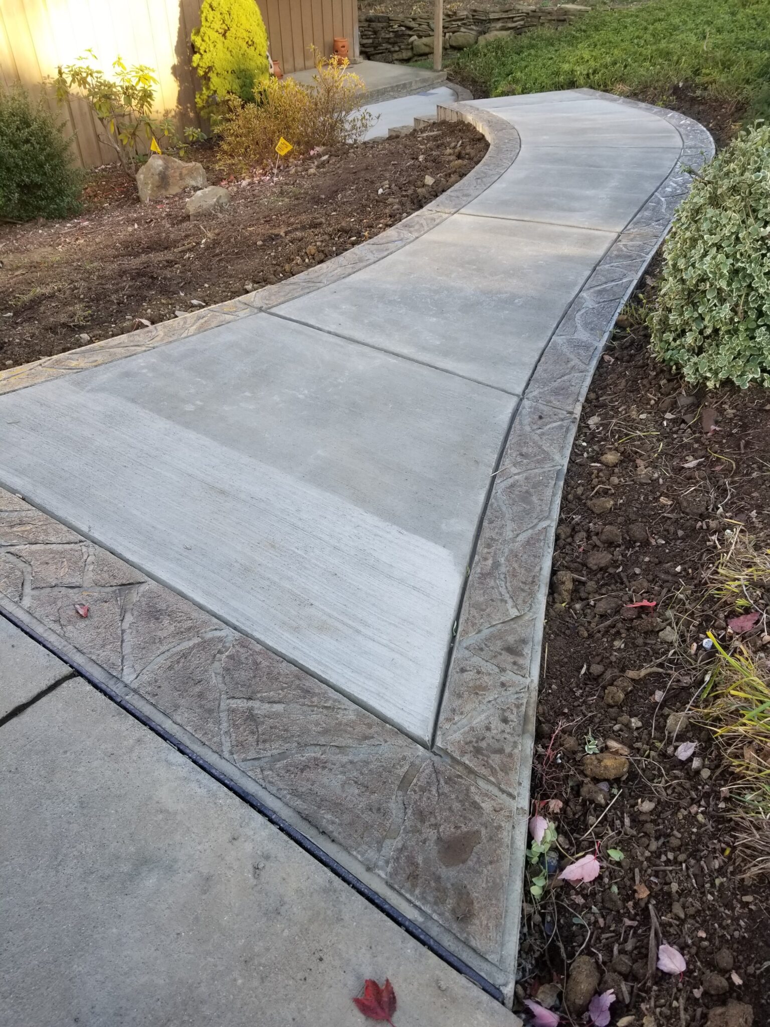 A walkway with concrete and stone border