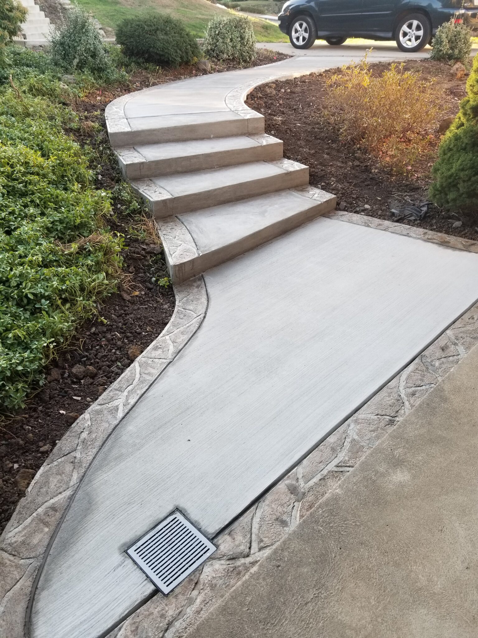 A walkway with steps and a metal grate.
