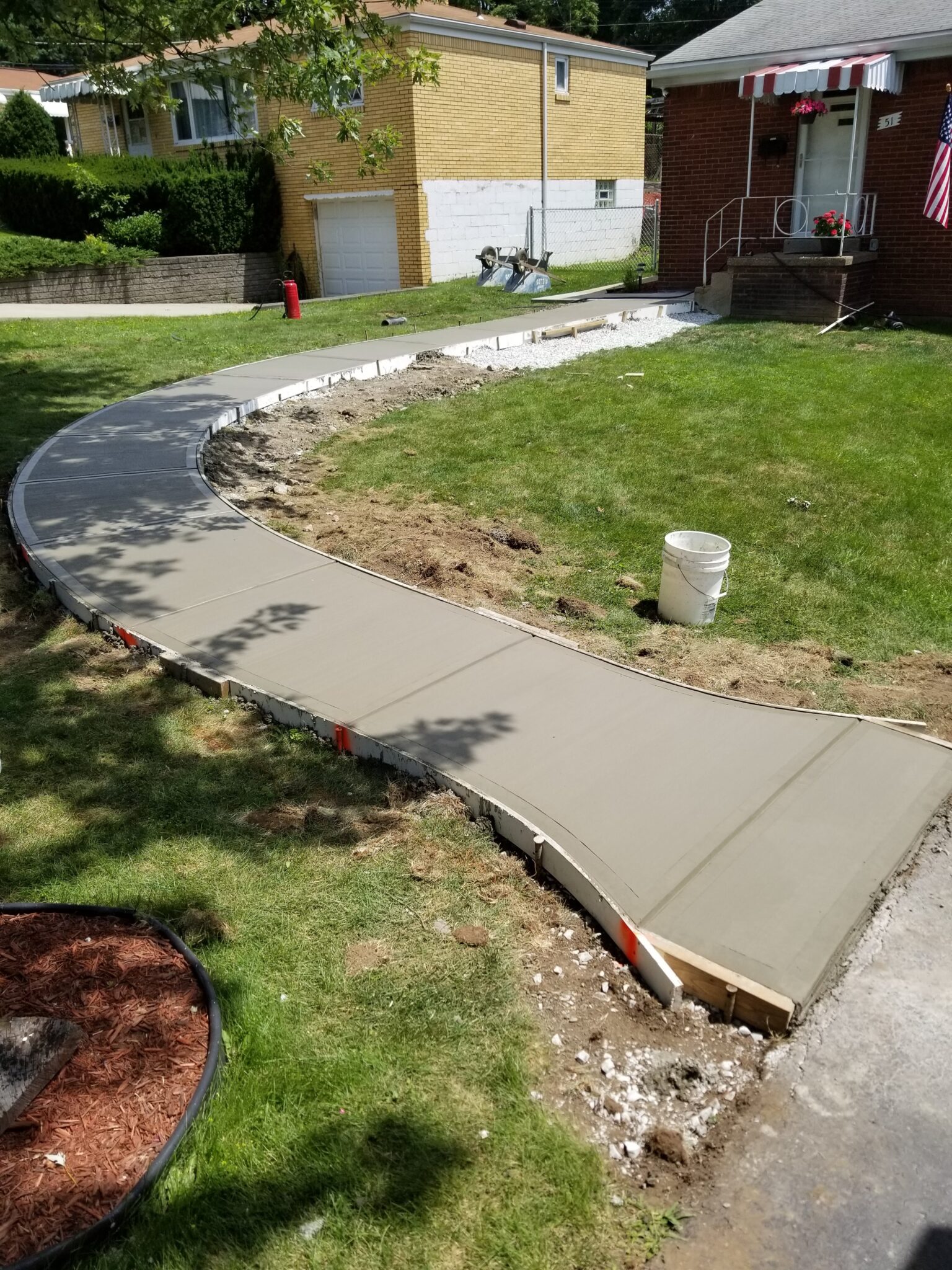 A concrete walkway in the middle of a yard.