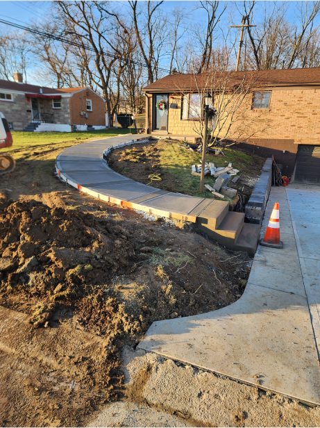 A house with a sidewalk and a pile of dirt.