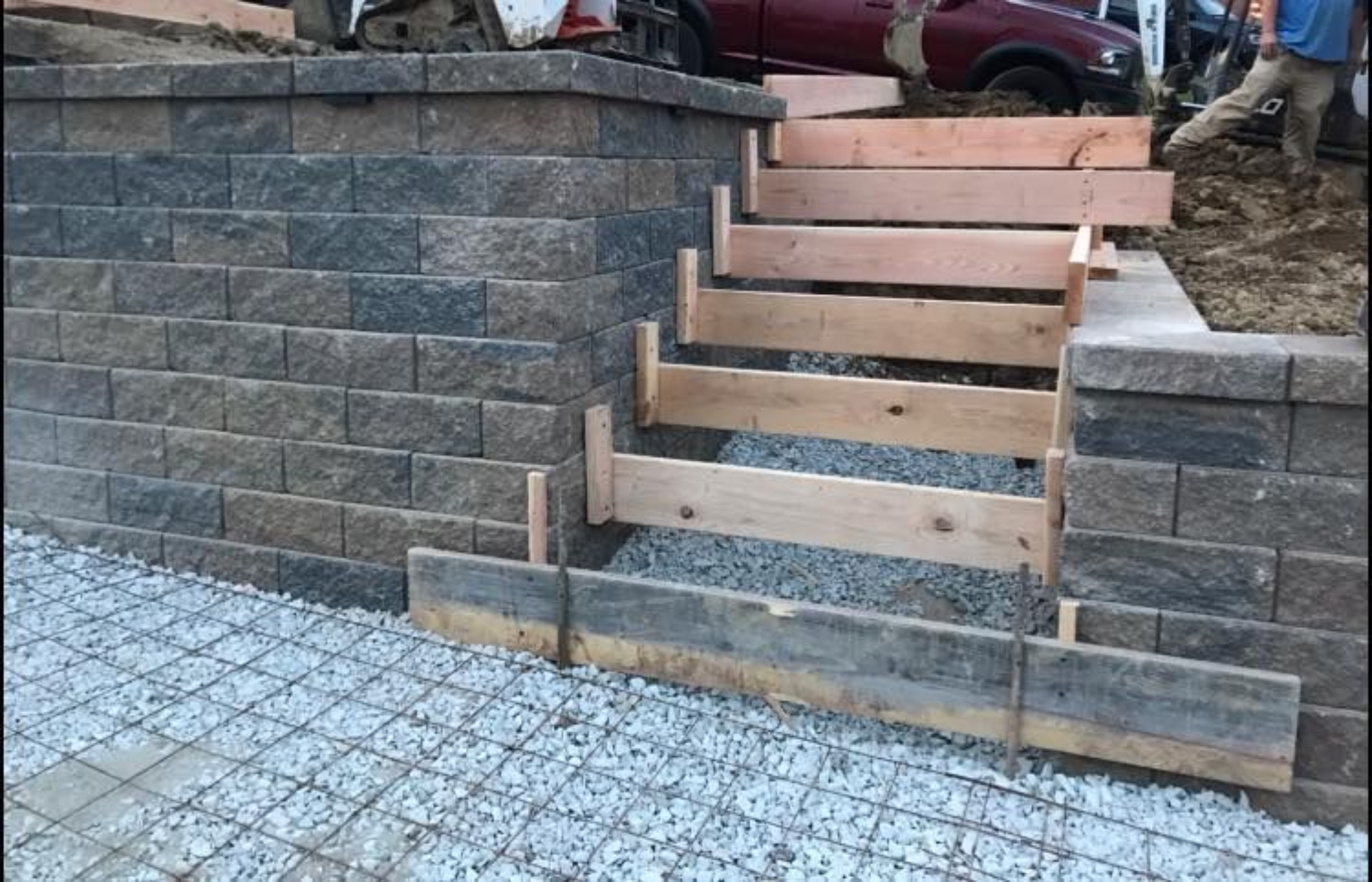 A brick wall with steps and wood stairs.