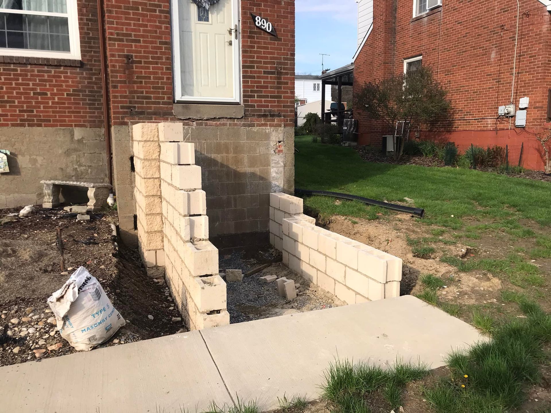 A brick wall is being built in front of the house.