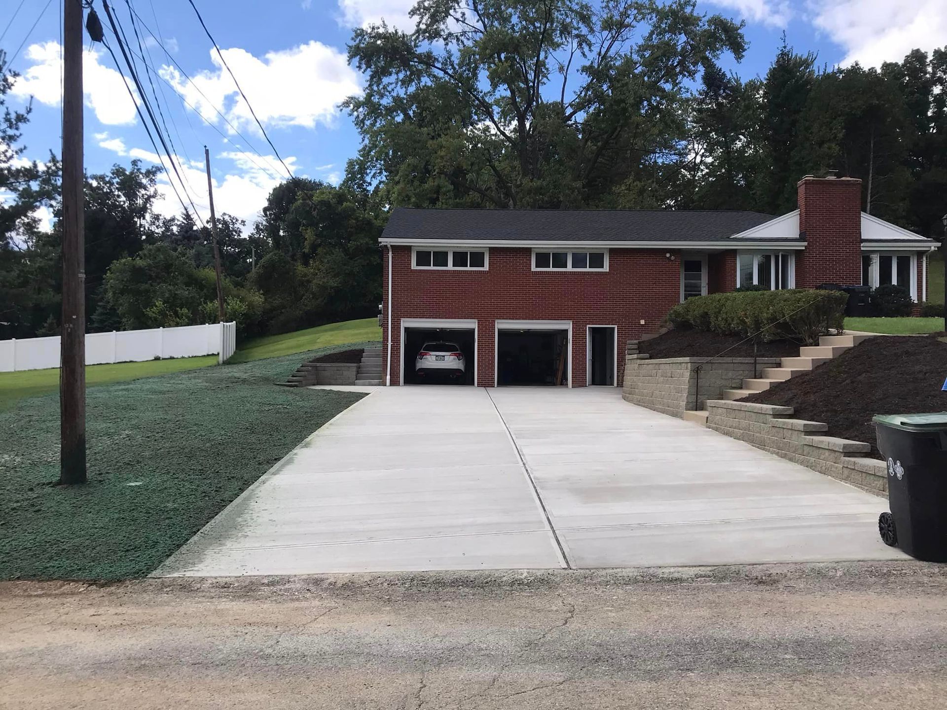 A driveway with two cars parked in it.
