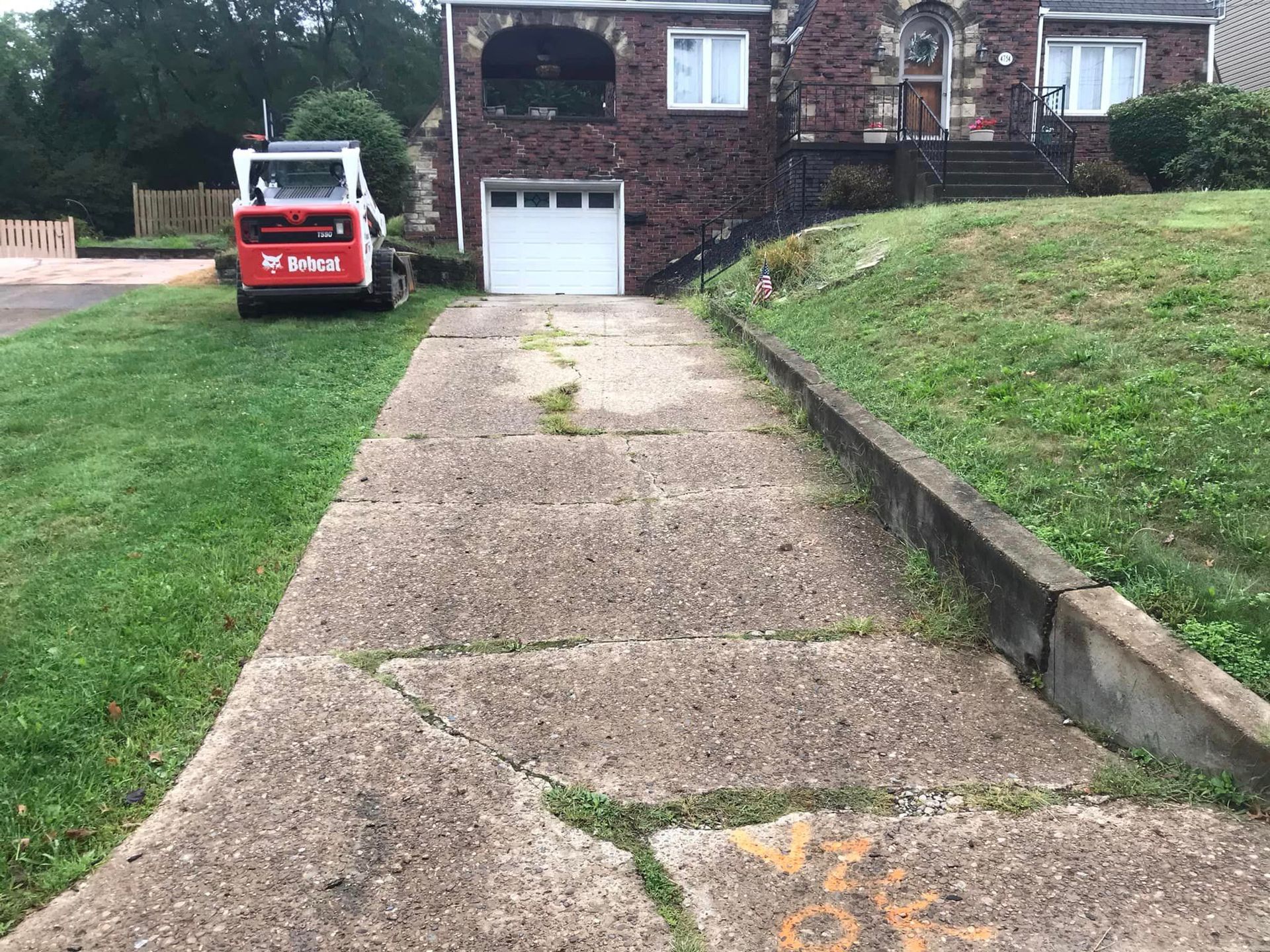 A driveway with no one in it and a truck parked on the side of the road.