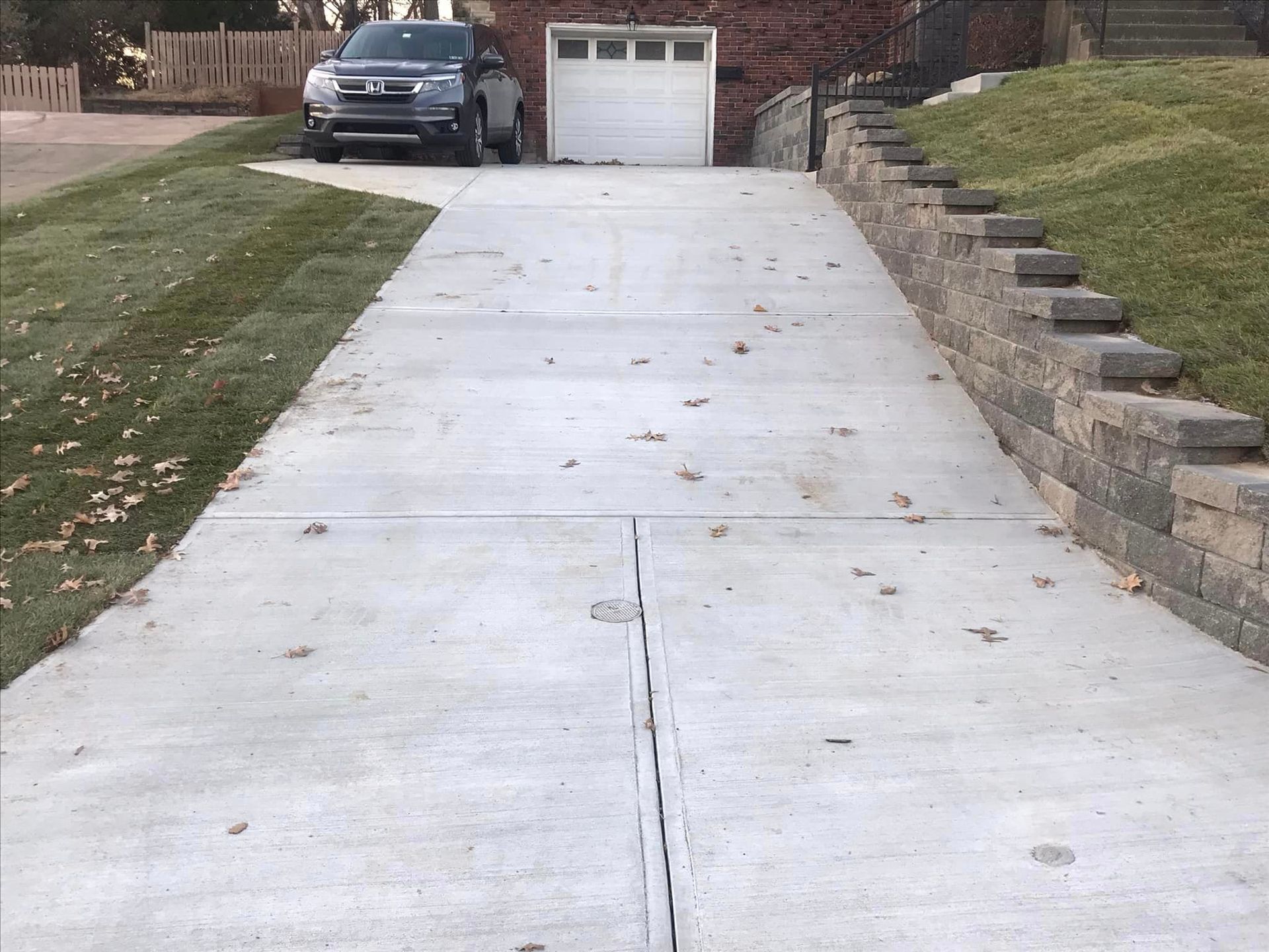 A driveway with a car parked in it