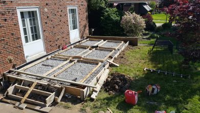 A deck being built in the yard of a house