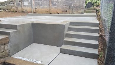 A concrete slab with steps and a wall.