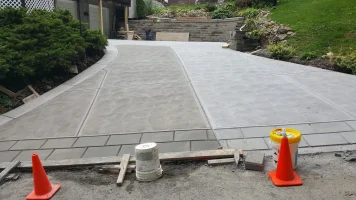 A driveway with concrete on the side and cement on the bottom.