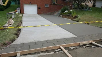 A driveway with concrete and yellow tape around it.