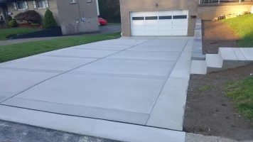 A driveway with concrete on the side of it