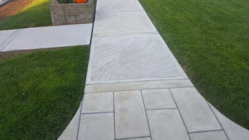 A walkway with grass and concrete in the middle of it.