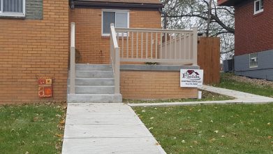 A house with stairs leading to the front door.