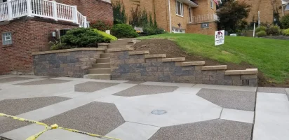 A driveway with steps and stairs leading to the house.