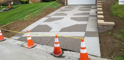 A driveway with orange cones and white lines.