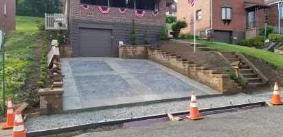 A street with a cement driveway and a flag on the side.