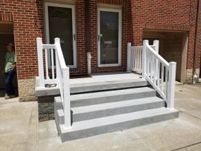 A white staircase with steps leading to the front door.