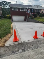 A driveway with orange cones on the side of it.