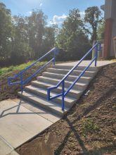 A set of stairs with blue railing on each step.
