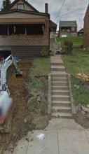 A picture of the back yard with stairs going up.