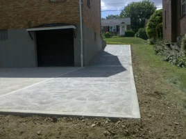 A driveway with a concrete slab and sidewalk.