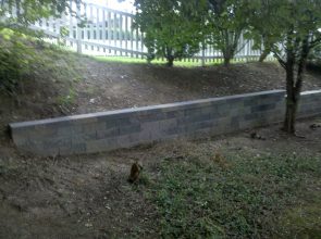A concrete wall in the middle of a yard.