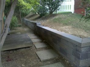 A concrete block wall with steps leading to the ground.