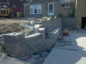 A brick wall being built in front of a house.