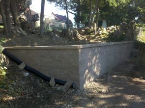 A concrete wall with a pipe sticking out of it.