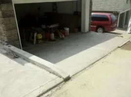 A red van parked in the garage with its door open.