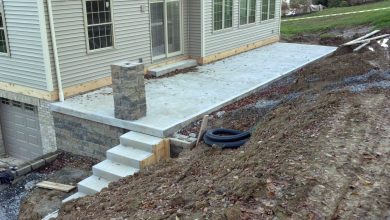 A patio with steps and a stone wall.