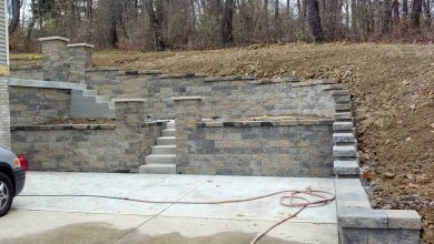 A stone wall with steps and stairs leading to the top.