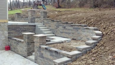 A man is building a stone wall with steps.