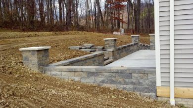 A stone wall with pillars in the middle of it.