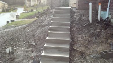 A concrete staircase is shown on the side of a hill.