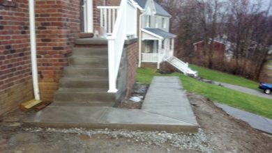 A concrete walkway leading to the front door of a house.